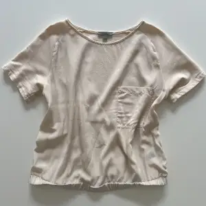Cremevit/ljusbeige t shirt med ficka från Cos i nyskick 🤍