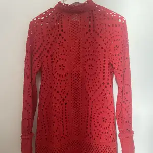 Röd klänning med hålbroderier från H&M, saknar en knapp där bak men inget som påverkar hur den sitter! Köparen står för frakt