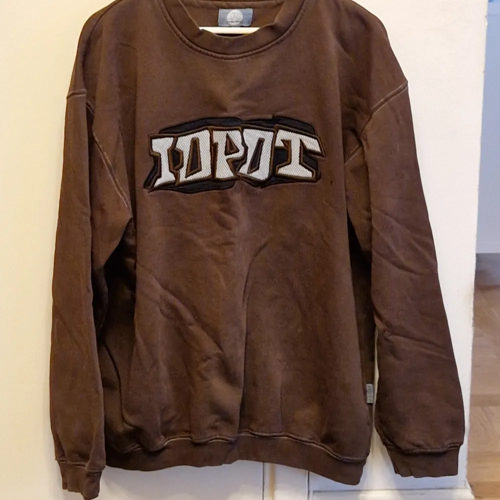 Säljer en retro sweatshirt från märket IDPDT i XXL men passar som XL. Den har en del tecken på slitage på olika delar av tröjan, men är annars i acceptabel skick! . Hoodies.