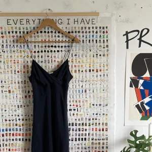 Svart klänning - Klänning från ”Riley”, köpt på second hand men knappt använd av mig och i mycket gott skick. Den har en underklänning i ett sidenliknande tyg och en överklänning i genomskinligt svart lätt tyg. Dragkedja på sidan.