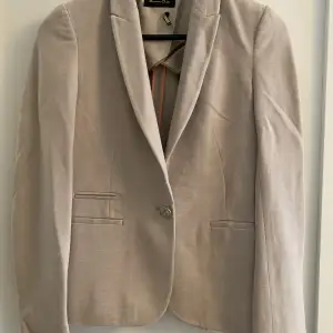 En klassisk beige kavaj från Massimo Dutti.  Mycket bekväm och fin!  Använd bra skick 