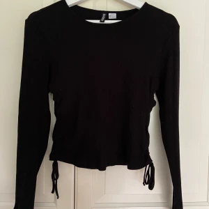 Topp med snörning  - Ribbad topp från H&M i stretch som aldrig är använd. 