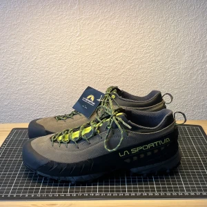La Sportiva TX4 (44) - Sprillans nya skor från klättermärket  La Sportiva. Fel storlek för mig men passar säkert någon annan där ute.   Storlek:  EU 44 UK 9,5 US 10,5 Färg: Turtle/Lime Punch  Har aldrig använts ute utan bara testats inomhus.  Hojta om ni har några frågor!  