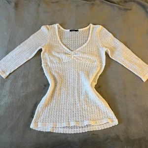 Stickad tröja - Denhär tröjan har två söta pärlor och en liten rosett därfram. Armarna är halva och den är förvånansvärt varm för att vara så tunnt stickad. Skriv privat om ni har frågor eller vill ha fler bilder💕