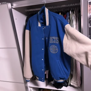 College jacka  - College jacka köpt på Urban Outfitters. Märke Iets Frans. Gjord i mocha material, stilrena beiga armar & resten är i en blå färg. Riktigt fin jacka jag tyvärr växt ut ur, storlek L. Ord pris 1200. Liten flaw på armen. Frågor så skriv. Du står för frakten.