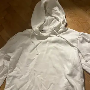 En vit hoodie som är kortare (cropped), med lite puffärmar. Hoodien är i storlek xs/s, och kommer från lager 157!😊