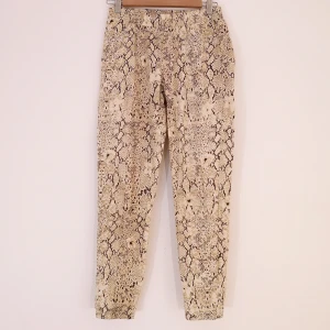 SPELL byxleggings Strl M - Byxleggings från märket SPELL köpt för ca 500kr. Har två bakfickor. Har resår i midjan. Färgerna är beige, brunsvart och äggskalsvit skulle jag säga. Färgerna är varmare än de ser ut på bilderna. 