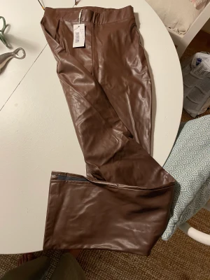 Nelly ”skinnbyxor” vida, nya - Skinnimitation Nelly ”side cut pants”, ett par beiga och ett par bruna stl xs