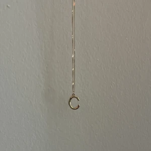”C” halsband  - Säljer detta gulliga halsbandet med ett c som är guldigt. Halsbandet är i nyskick och endast använd 2 gånger 
