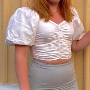 Topp frn Gina Tricot  - En kort vit topp från Gina Tricot med puffärmar. Andvänd ca 5-10 ggr så den är i ett bra skick🤩storlek 36 