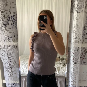 Volang topp - ”Lila” (lite svårtolkad färg) topp med volanger. Den är stickad i materialet o väldigt stretchiga. Från Hm storlek S💕 100kr+ frakt 