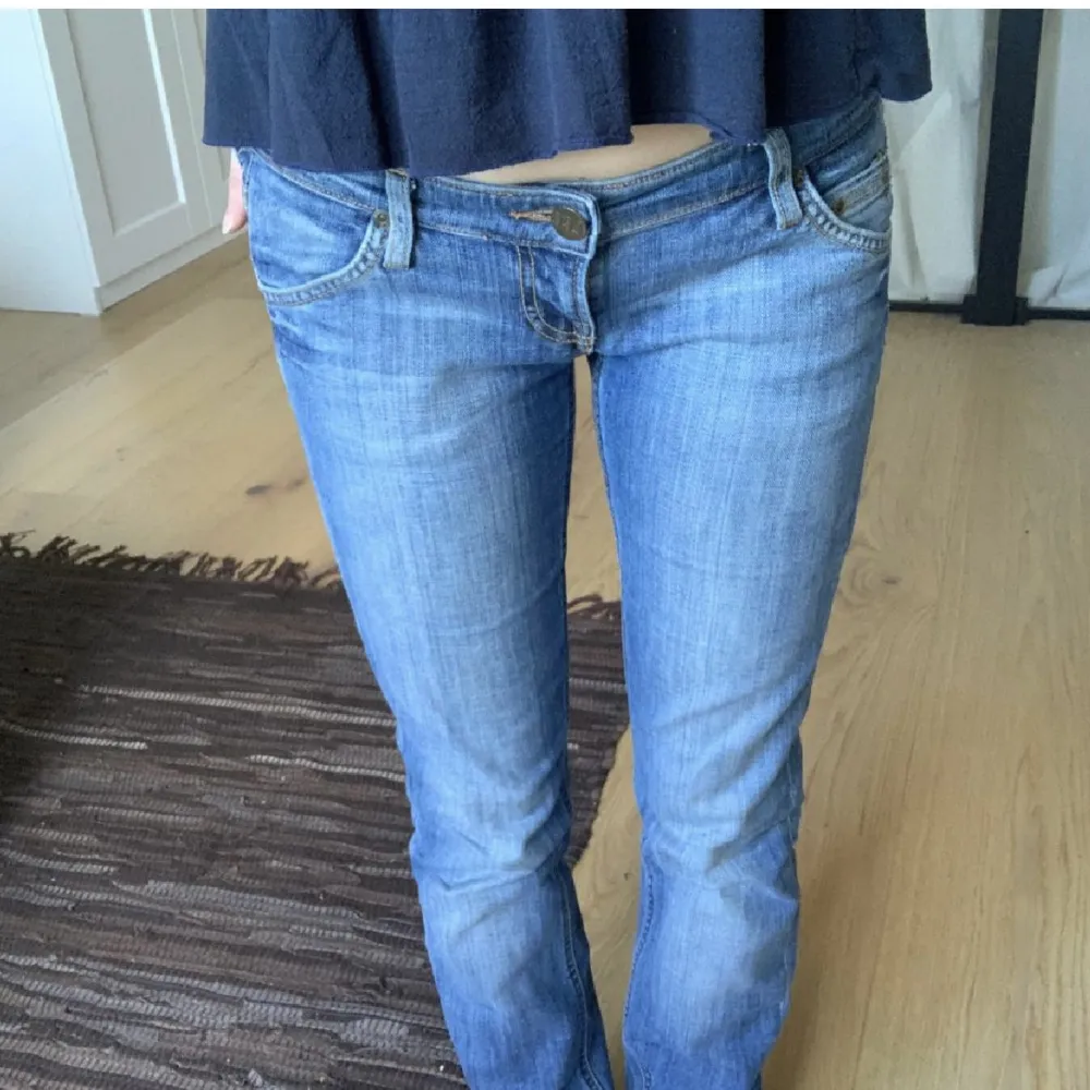 Sjukt snygga lågmidjade raka jeans från Lee, storlek W26 L33. Midjemått 76 cm (omkrets) och innerbenslängd 81cm, de sitter långt ner på höfterna (se bild). Säljer då de tyvärr är för långa på mig som är 162cm. . Jeans & Byxor.