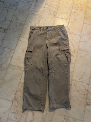 Gråa Manchester byxor  - Bra skick 8/10 Använda ett fåtal gånger (för stora)  Betalning via Swish och köparen står för frakten 