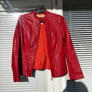 Vintage läderjacka leatherjacket skinnjacka bikerjacket bikerjacka motorcykeljacka rödjacka jacka  - Fantastisk röd vintage läderjacka (äkta läder) i fint skick säljes. Inga fläckar eller dylikt, ljuset och smuts på spegeln får det att framstå så. Strl: M. 
