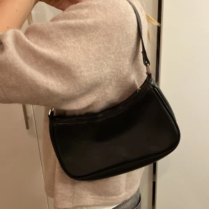 Snygg svart väska  - Den är andvänd men i bra skick förutom en liten fläck röd färg men den är inget man märker.