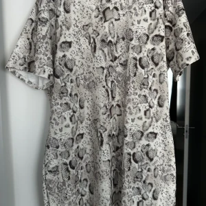 Highneck klänning  - Highneck kort klänning, ormmönstrad med kortärm. Använd 1 gång.  Nypris 299