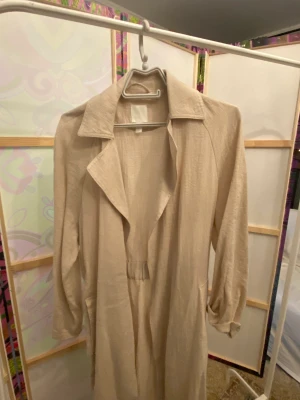 Beige trenchcoat - Beige trenchcoat från H&M. Säljs på grund av att den inte används.