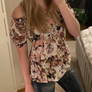 Blommig topp  - Fin blommig of shoulder topp, står ingen storlek med skulle tippa på att den är en s/m 
