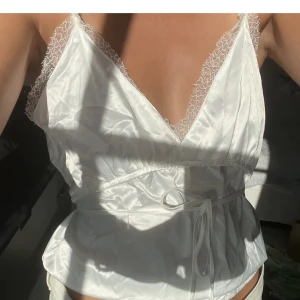 Vitt satin linne med spets🤍 - Så fint vitt satinlinne med spets och band som går att knyta åt både fram och bak🙏🏼 Superfint skick då det nästan aldrig använts🤍Funkar perfekt till fest och vardag, säljer även en likadan i svart❤️