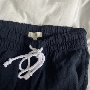 Marinblå linnebyxor  - Marinblå linnebyxor från H&M i storlek S. Knappt använda så är inprincip i nyskick! De är förkorta för mig som är 176 cm så skulle säga att de passar de som är under 170 cm. 