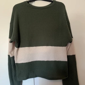 grön/vit tröja - säljer den här tröjan då jag inte tycker om den. tröjan är längre i ärmarna än vad den är på kroppen. på några ställen så är tröjan lite nopprig, kontakte vid fler bilder eller vid frågor!! <33