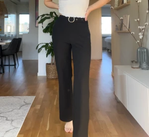 Svarta raka byxor  - Svarta raka byxor i polyester. Lite skavt på knappen (se bild 3). 