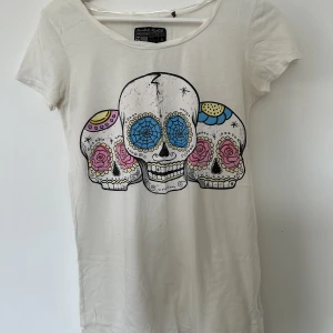 T-shirt  - Vit/beige t-shirt med tryck från Saints & Mortals. Använd fåtal gånger. 50% cotton / 50% viscose  Storlek S ✨✨✨