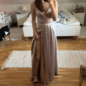 Balklänning - Balklänning i satin köpt på Ivory Field, färgen är typ nude åt det rosa hållet💕Nypris 3300kr, endast använd en gång💕  Passar mig som brukar ha 34/S och är 166 + klackar ca 8cm 