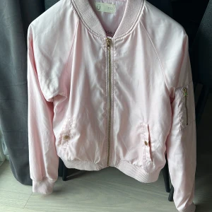 Bomberjacka  - Rosa bomberjacka ifrån Kappahl ! Strl 170 men jag har strl M och den passar mig. Säljer för 190kr, finns en liten fläck men går säkert bort i tvätten! 