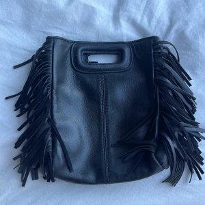 Maje väska - Maje väska i lilla modellen som tyvärr inte kommer till användning längre. Fint skick trots några år gammal. De märkbara slitningarna är andra bilden på handtagen. 