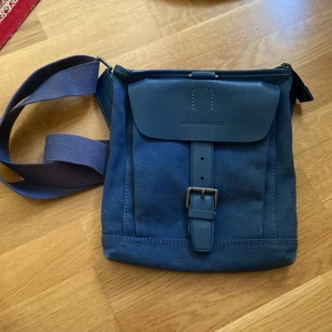 Väska - En blå axelremsväska från Mandarina Duck med en massa påhittiga fack!💓