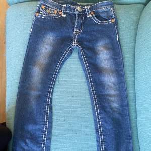 Ett par true religion jeans för barn. De är i bra skick och inga defekter. 65cm i midjemått (runt om) och 62cm benlängd från skrevet, ned. Somsagt barnstorlek, tror typ för barn i 7-10år-åldern.