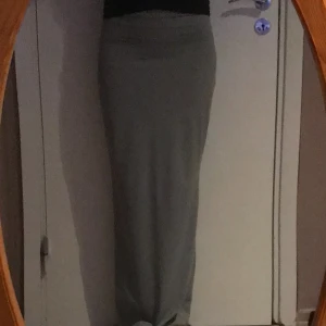 Lång lågmidjad kjol  - Lång lågmidjad kjol. Kjolen är i storlek S, kjolen är i bra längd för mig som är 162cm. Kjolen är stretchigt och lätt att gå i. Det är typ baddräkt material.  Kjolen är typ ljusgrön eller typ grå. 