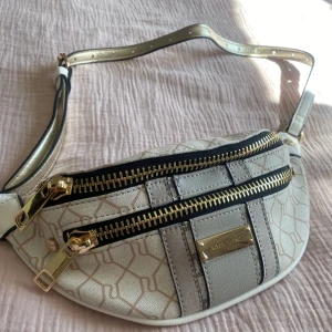 Cros over body bag  - Helt ny väska, aldrig använd. Plasten är kvar, vilket bild 3 visar. Justerbart band. 