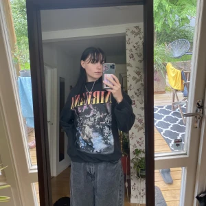 Nirvana collegetröja - En nirvana collegetröja, lite högre i kragen. Lite urtvättad svart färg