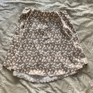Beige Blommig Kjol - En lätt kjol av glansigt material 🤎 Är XS men passar S också.