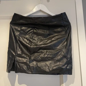 Kjol - En svart fake läder kjol med slits. Köpt från SHEIN och är i storleken L. Säljer för 15 kr + frakt