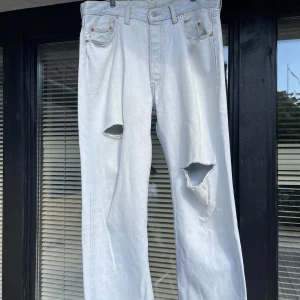 Blekta Levis jeans 501 storlek 34x32 - Blekta Levis Jeans modell 501 W34 L32 som är lite slitna med hål där fram och ett där bak vid ena fickan. Passar bra och är bra byxor om man vill ha hål på knäna