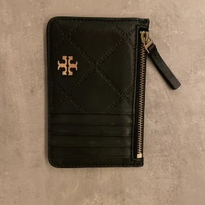 Tory Burch  - Plånbok/korthållare svart och guld. Med dragkedja. 