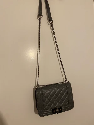 Grå axelväska  - Liten grå söt Axel väska, har tappat lite färg där man stänger den men i övrigt bra skick😊