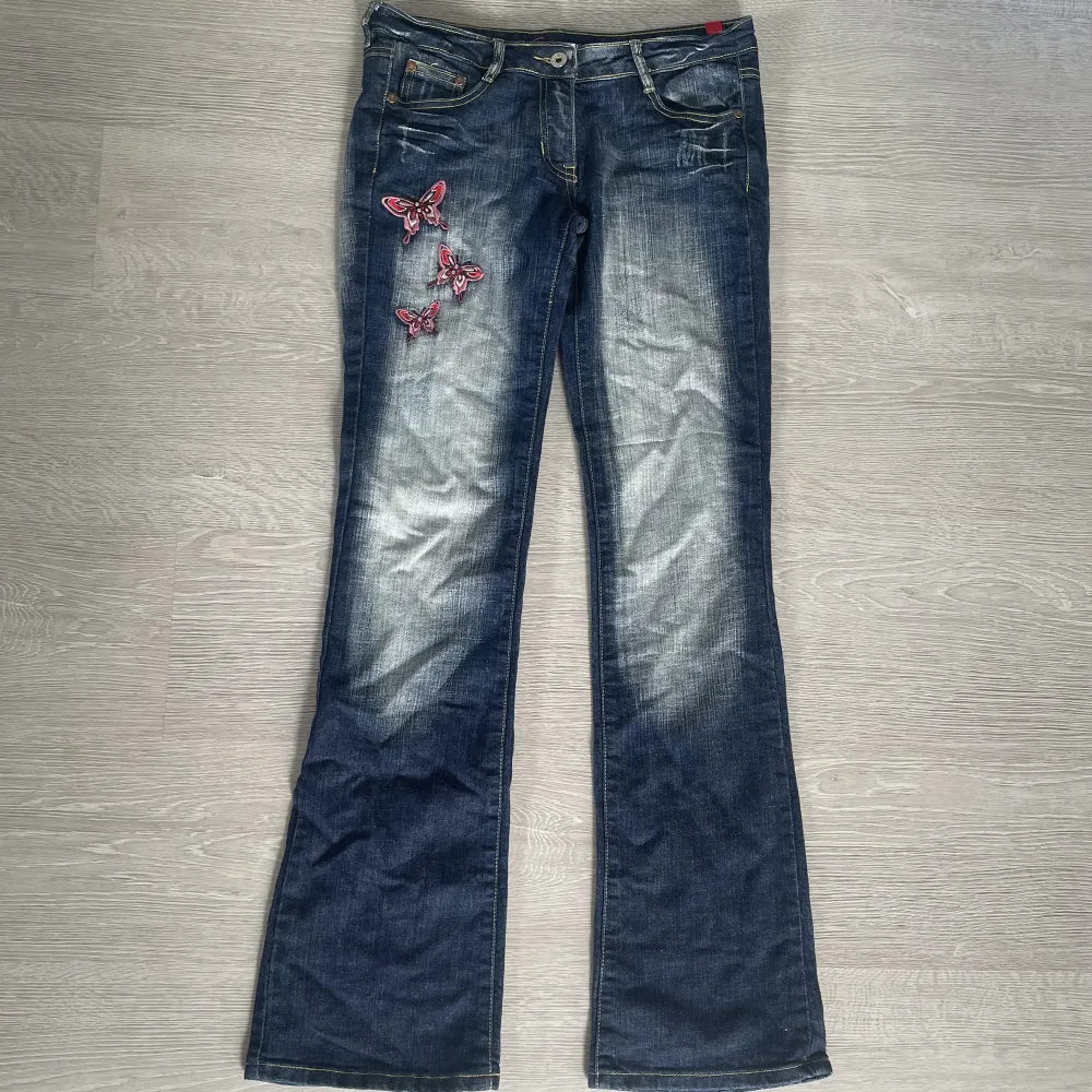 Lågmidjade jeans med bootcut/flare och broderade fjärilar💘 Crazy Age stil, bra skick!🌟 Mått: midja: 38cm(x2), innerbensmått: 85cm, midjehöjd: 19cm💞. Jeans & Byxor.