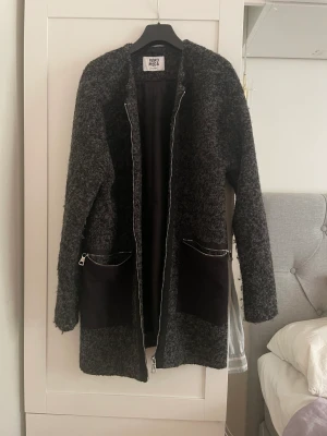 Kappa - Rak kappa från Vero Moda med två djupa fickor framtill. 