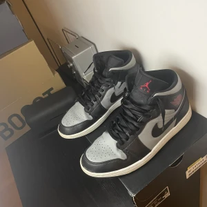 Jordan 1 mid shadow red - Jag säljer nu mina Jordan 1s för dom är för små. Dom är köpta från restocks.com och är äkta. Jag har kvar lådan men inte kvitto. Skicket är runt 7/10. Dom är lite creasade men annars är det inget fel på dom. Strl 44. Köpare står för frakt. Nypris ca 3500.
