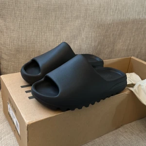 Yeezy slide onyx - Äkta yeezy slides i onyx/svart. Helt nya och oanvända, skriv gärna om du har några frågor