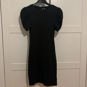 Svart klänning - Svart klänning med puffig ärm, bra skick