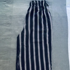 Randig svart vit byxor i stl 36 - Breda ben, st 36, midjan regleras genom en gummi som finns insidan och utsidan finns den bältet 