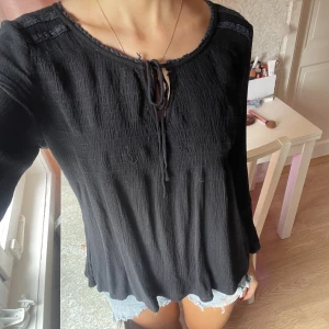 Svart blus - Aldrig använd, köpt på second hand. Fint skick, är lite längre. Gullig och har knytning där fram