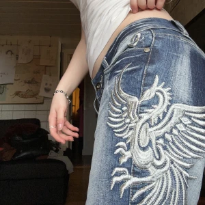 Lågmidjade emo jeans - Lågmidjade Bootcut Jeans som liknar crazy age med en cool drake på benet💙  Innerbenslängden: 67cm Midjemåttet tvärsöver: 40cm❣️