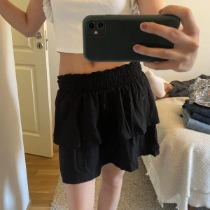 Volangkjol - Svart volangkjol i svart. Stretchig. Köparen står för frakten. 