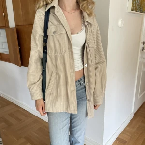 Jacka/kappa - Beige i Manchester material. Är strlk XS men sitter väldigt oversized